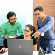 Three software engineers looking at computer code
