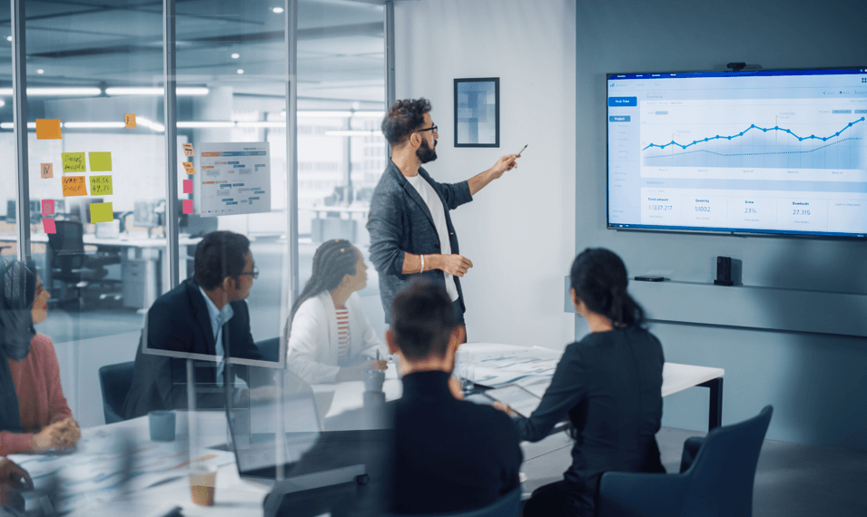 Manager leading meeting looking at warranty analytics data